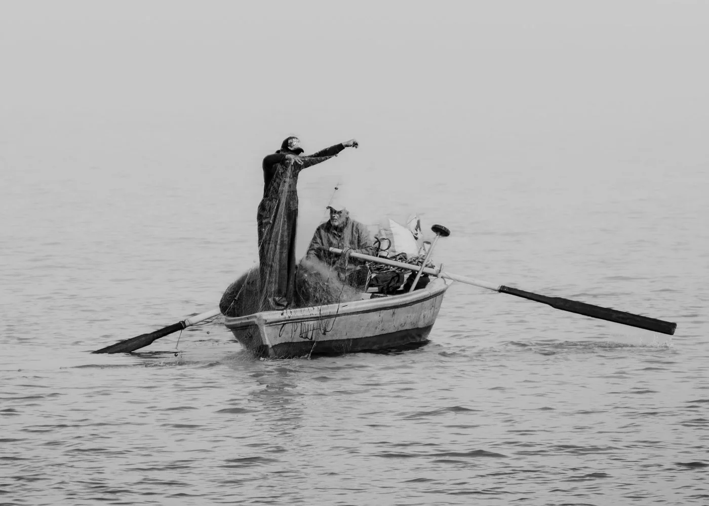 Pêcheur relevant son filet, tôt le matin